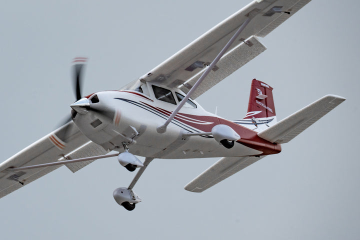 Red and white RC plane with dihedral wing.