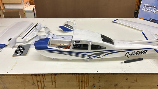 Detailed view of FMS Cessna 182 fuselage during assembly process with instruction manual