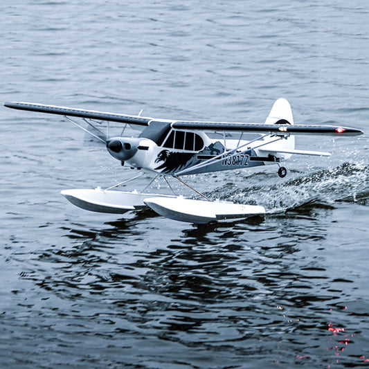 A seaplane skimming across a calm lake.