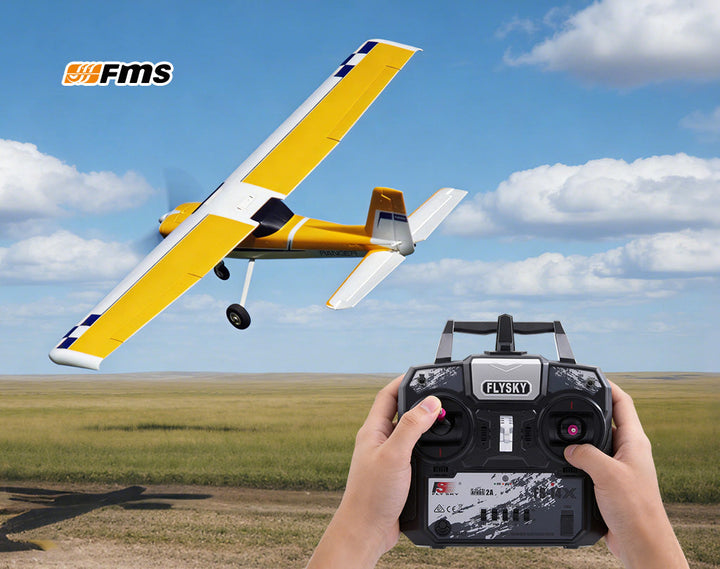 Hands holding Flysky remote control flying yellow FMS Ranger RC plane