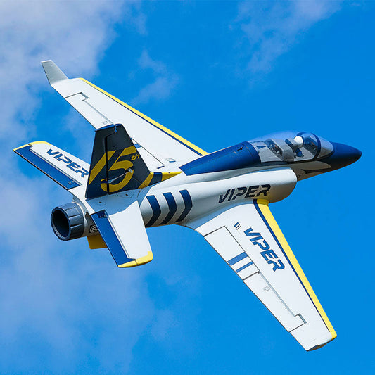 A white and blue RC jet airplane with "VIPER" branding on the wings and fuselage, featuring yellow accents and a sleek design, flying against a bright blue sky with scattered clouds.