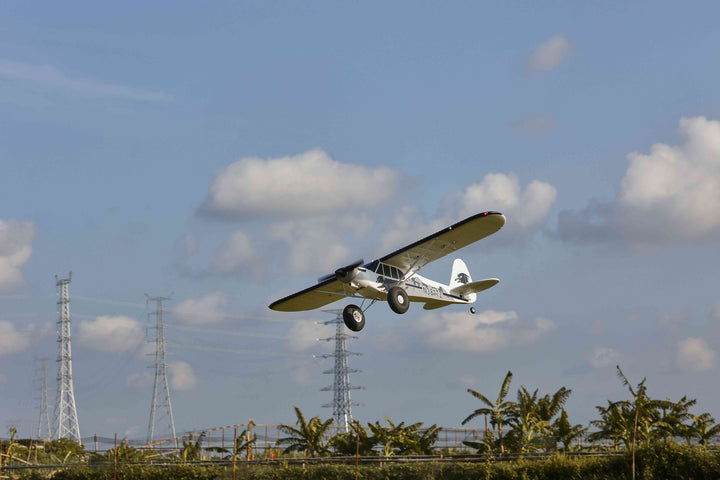 RC plane flying with power towers in background