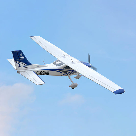 A white and blue FMS RC Plane model cruises smoothly through a clear blue sky