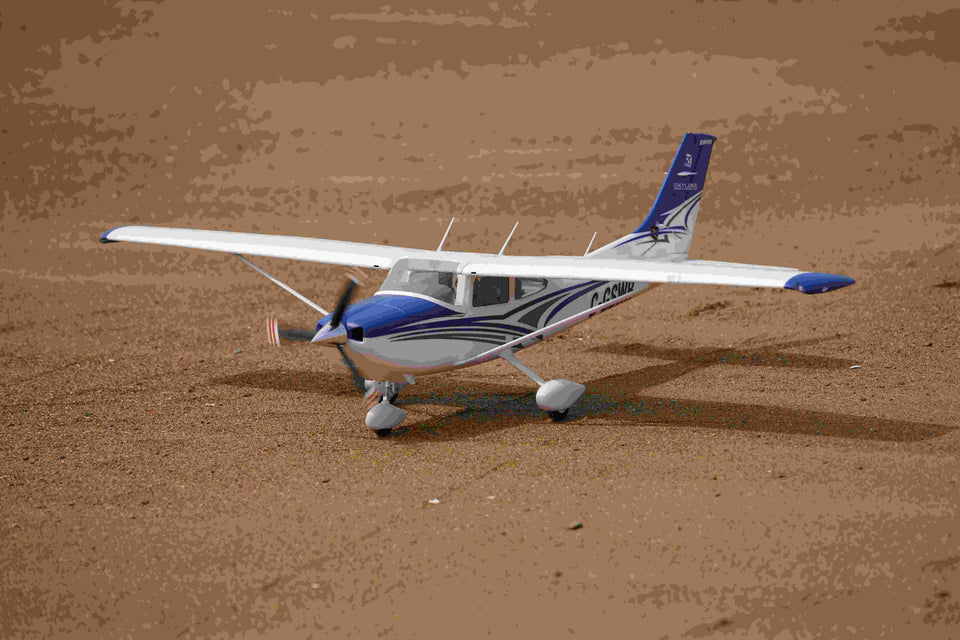 blue and white RC Cessna model on sandy ground