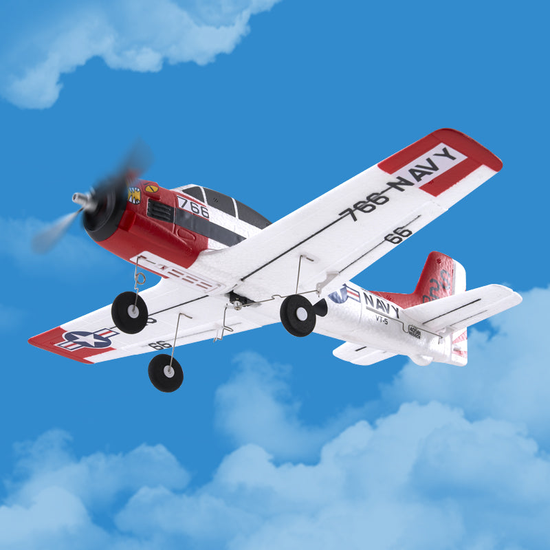 Model airplane with 'Navy' markings flying against a blue sky with clouds