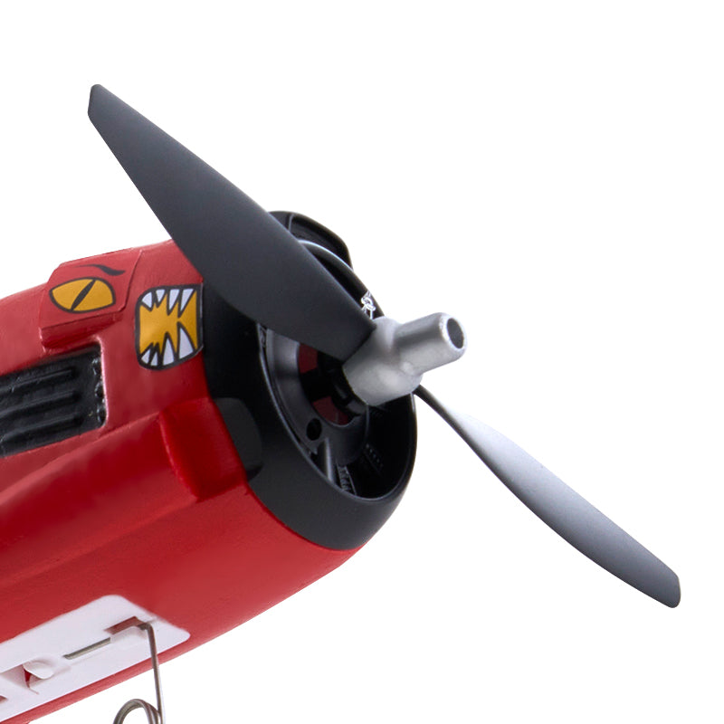 Close-up of a red toy airplane with a black propeller on a white background