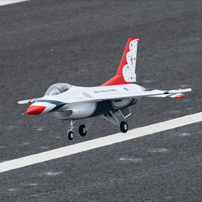 F-16 Thunderbird 64mm EDF jet model flying over a runway in vibrant colors