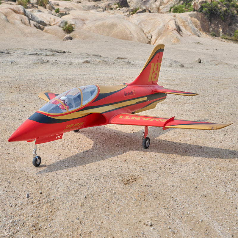 FMS 90mm Avanti EDF jet in vibrant red/gold, displayed on rocky ground.