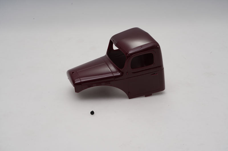 Maroon RC car body shell for customization, featuring a small black detail piece.