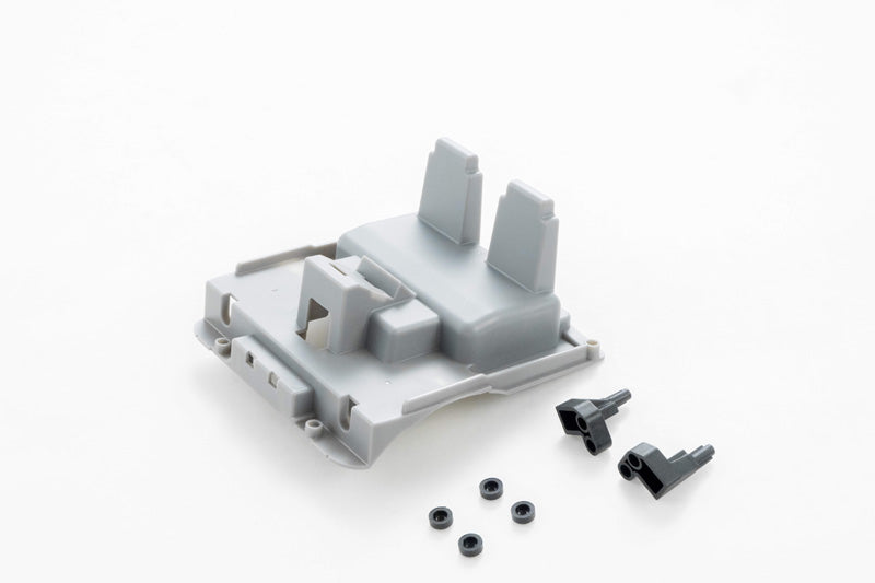 Gray RC vehicle part with mounting clips and screws for assembly.