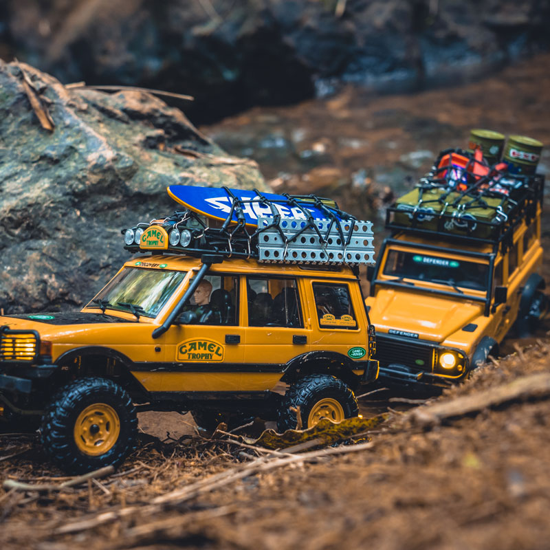 FMS 1:24 FCX24M Land Rover Discovery and Defender Camel Trophy Edition RC cars on a forest trail