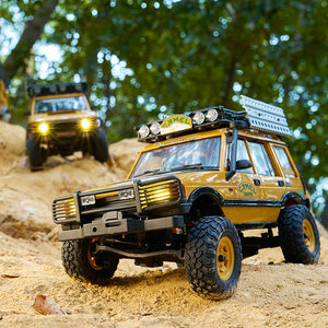 FMS 1:24 FCX24M Land Rover Camel Trophy Edition RTR RC car, yellow, detailed off-road vehicle with roof rack and large tires.