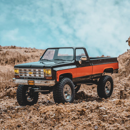 FMS 1:18 FCX18 Chevrolet K10 RTR black and orange RC truck model outdoors