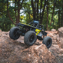 FMS 1:24 FCX24 Lemur RTR rock crawler on rocky surface with yellow detailing