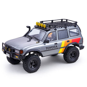 FMS 1:10 LC80 Toyota Land Cruiser 80 RS RC crawler in silver with yellow stripe, roof rack, and off-road tires.