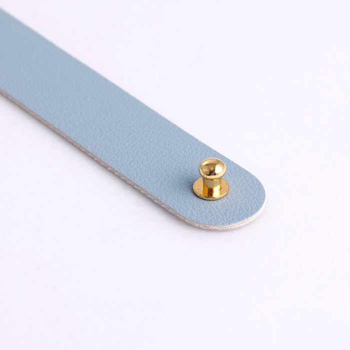 Detail of light blue cowhide mouse pad edge with brass snap button