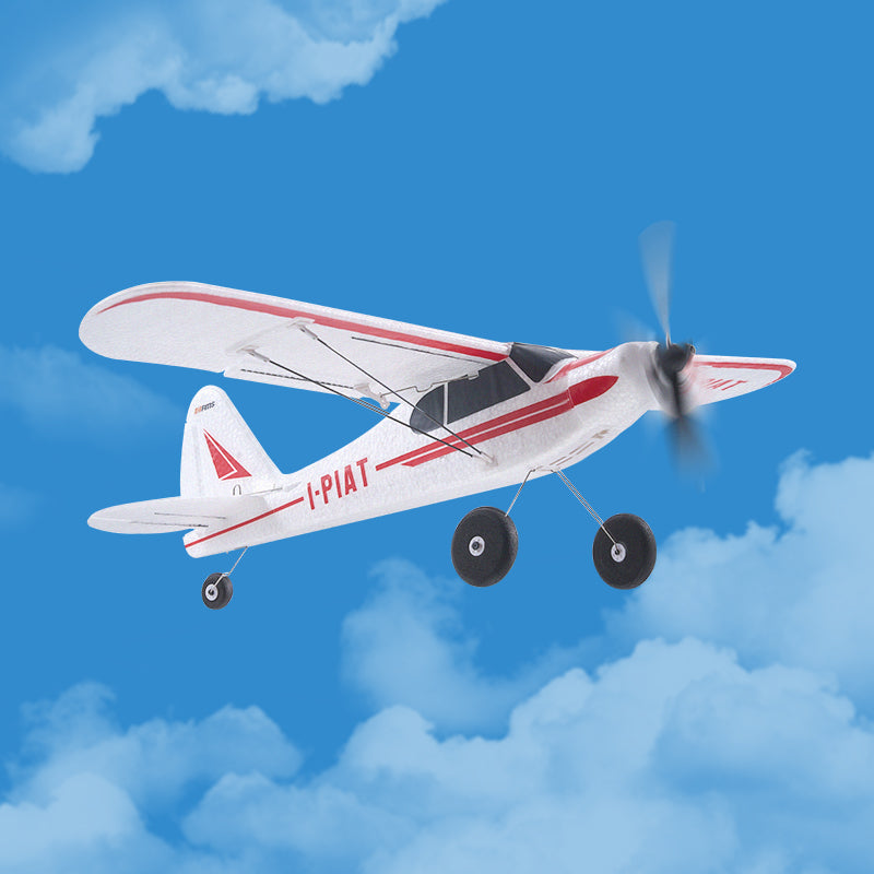 Model airplane with propeller against a blue sky with clouds