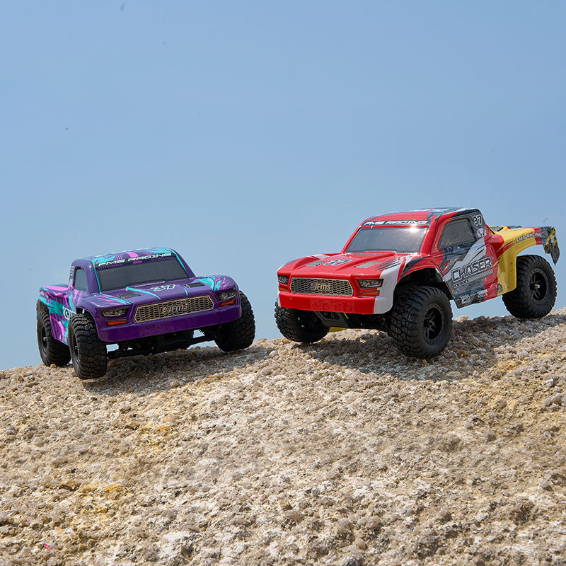 FMS 1:24 Chaser short course trucks: red/yellow and purple on dirt. Ideal for beginners.