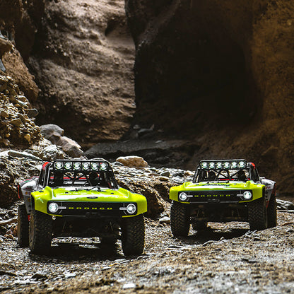 Two green off-road vehicles navigating a rocky terrain.