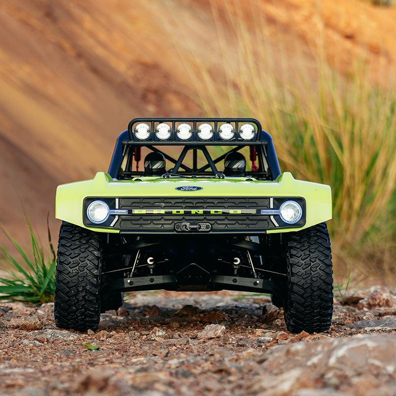 Green off-road vehicle with large tires on a rocky terrain