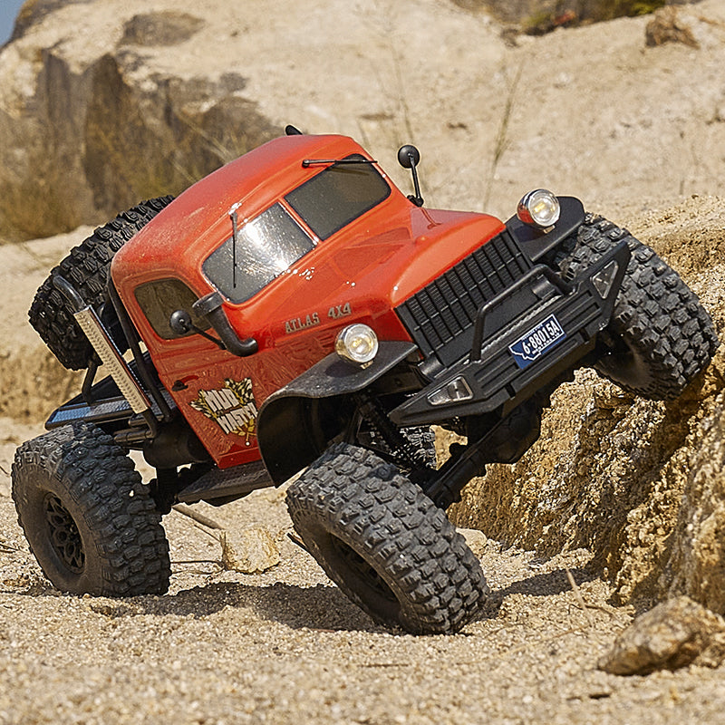 Red ROCHOBBY 1:10 Atlas 4x4 Off-Road Truck RS climbing rocky terrain with aggressive tires.