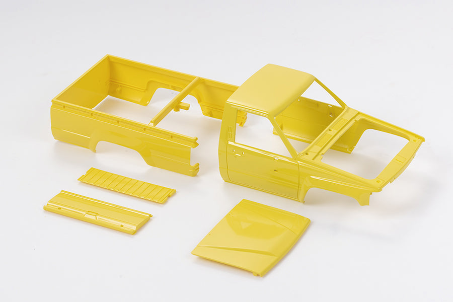 Yellow 1:18 Hilux body shell parts including cab and truck bed