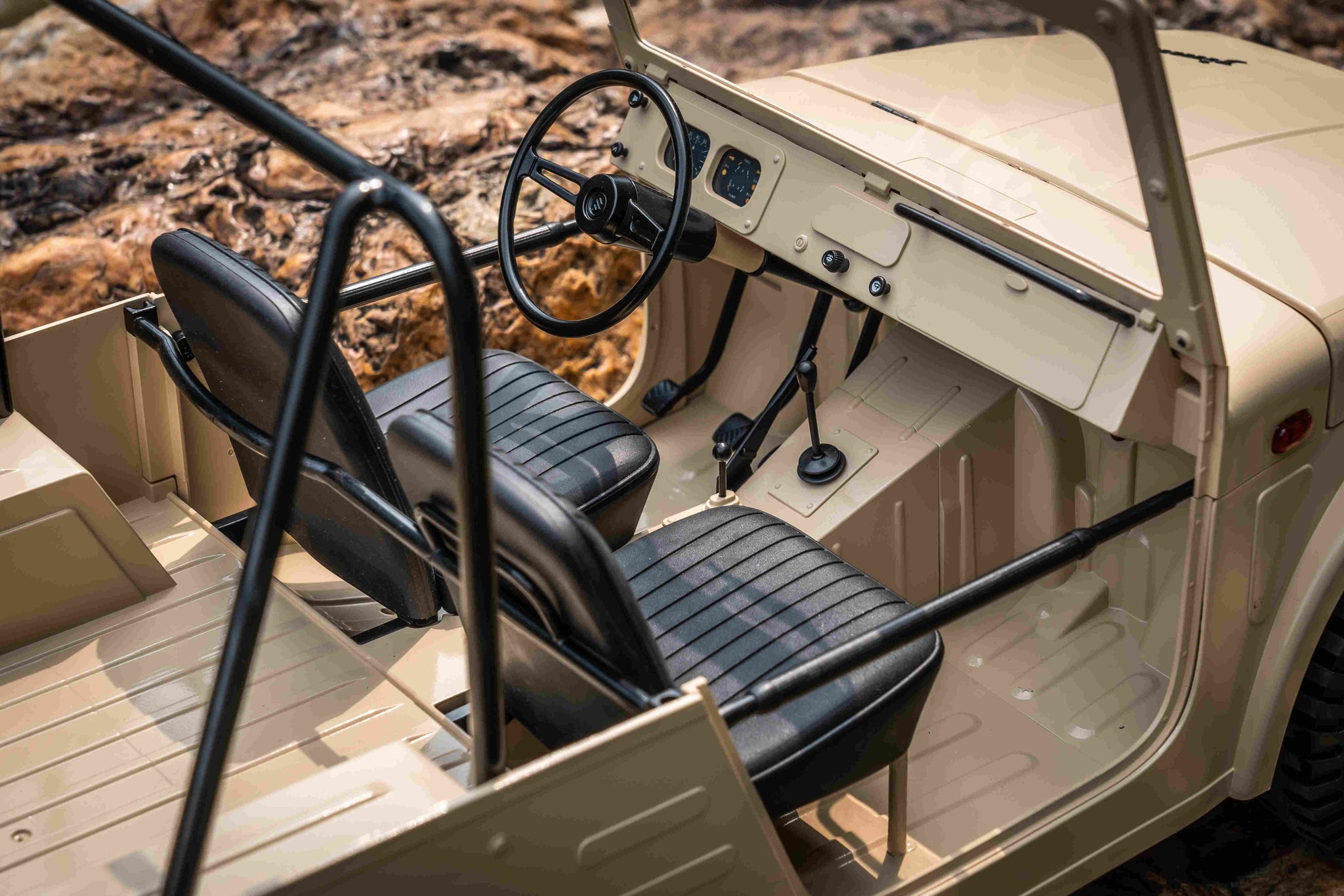 Interior of the FMS 1:6 Jimny RS Brown RC vehicle, featuring tan dashboard, black seats, steering wheel, and gear shifter.