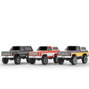 Three FMS 1:24 Chevy K5 Blazer RTR RC trucks in black, red, and yellow colors.