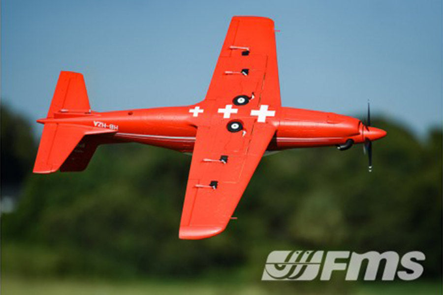FMS 1100mm PC-21 Pilatus PNP red RC airplane in flight with Swiss cross details and FMS logo.